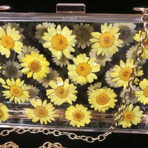 A PERSPEX CLUTCH WITH REAL DAISIES