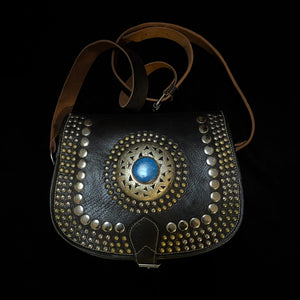 A HAND CRAFTED WESTERN STYLE STUDDED BAG WITH BLUE JEWEL