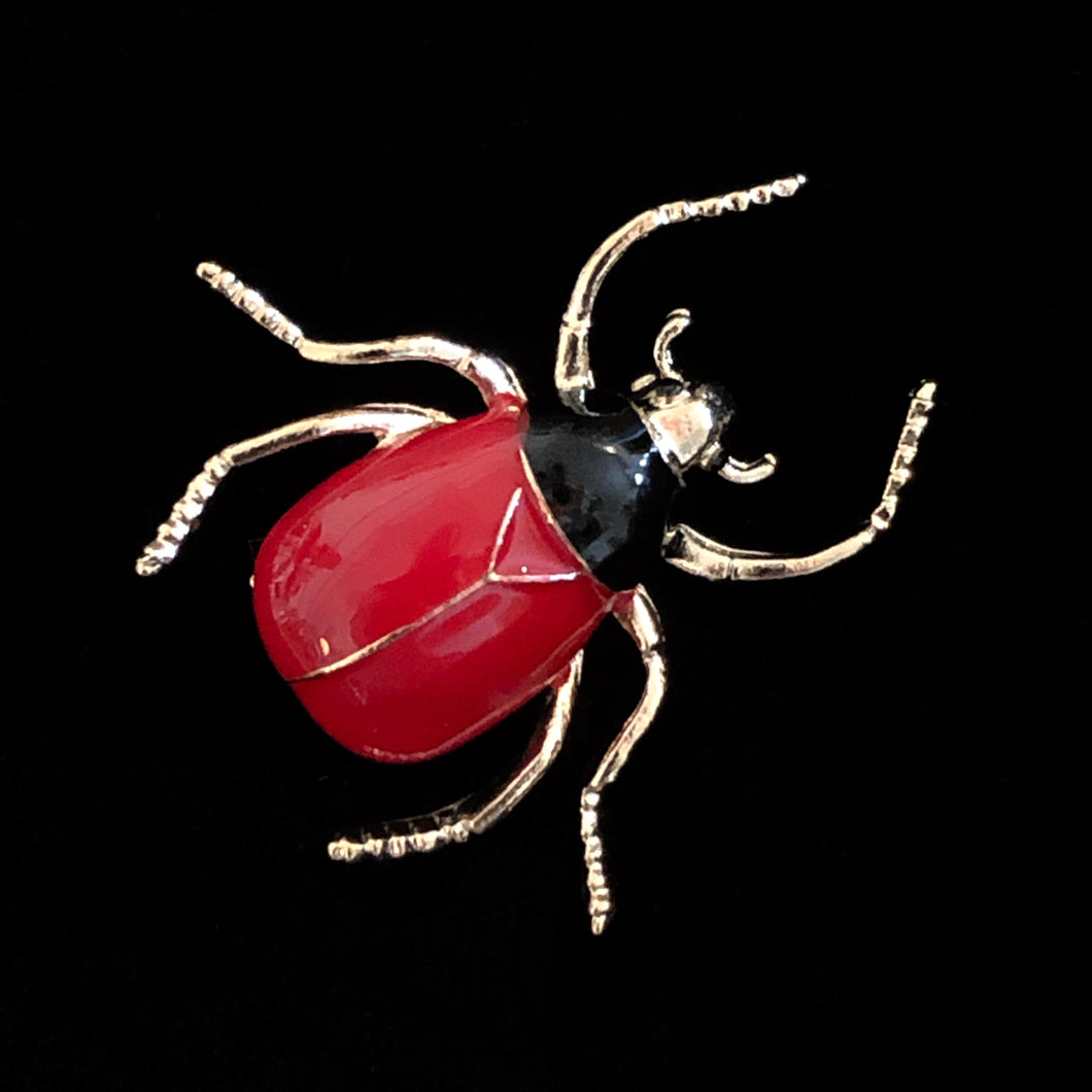 A RED AND BLACK ENAMELLED BEETLE BROOCH