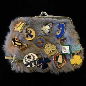 A KANGAROO SKIN PURSE WITH 28 VINTAGE GIRL GUIDE PINS.