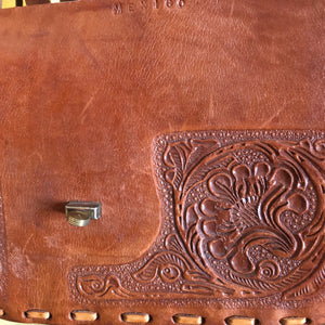 A VINTAGE TOOLED LEATHER SADDLE BAG FROM MEXICO
